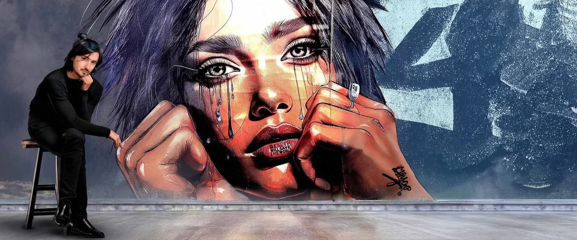 Miiyoo beside a wall mural of the portrait 'Beauty will save the world'